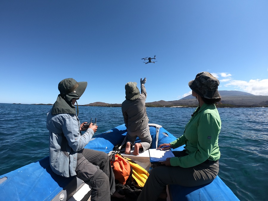 Three scientists are sitting on a boat, launching a drone © Andrea Varela